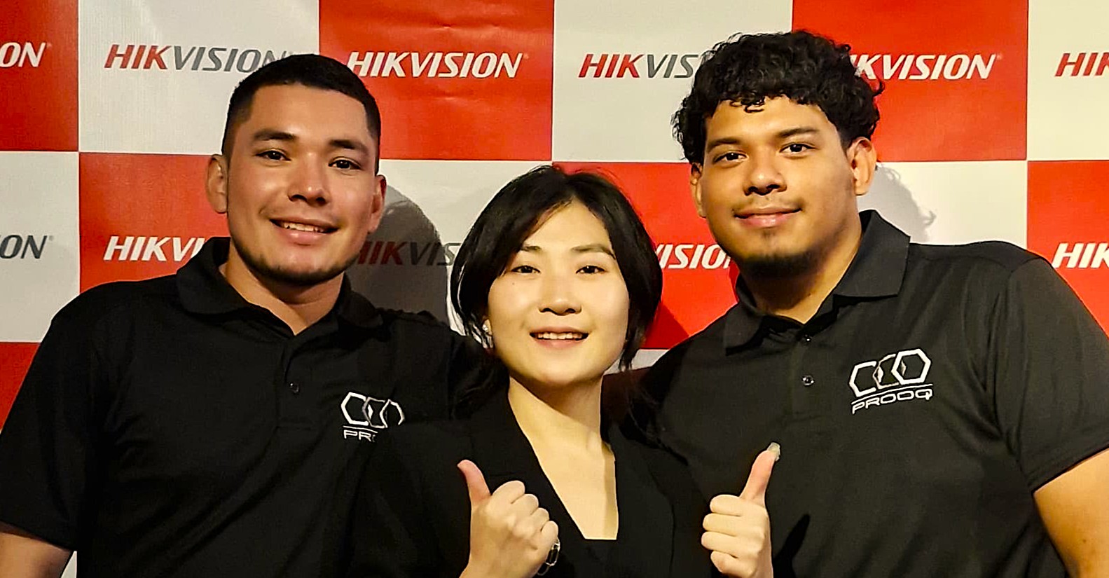 Tres miembros del equipo PROOQ en evento Hikvision, con actitud colaborativa.